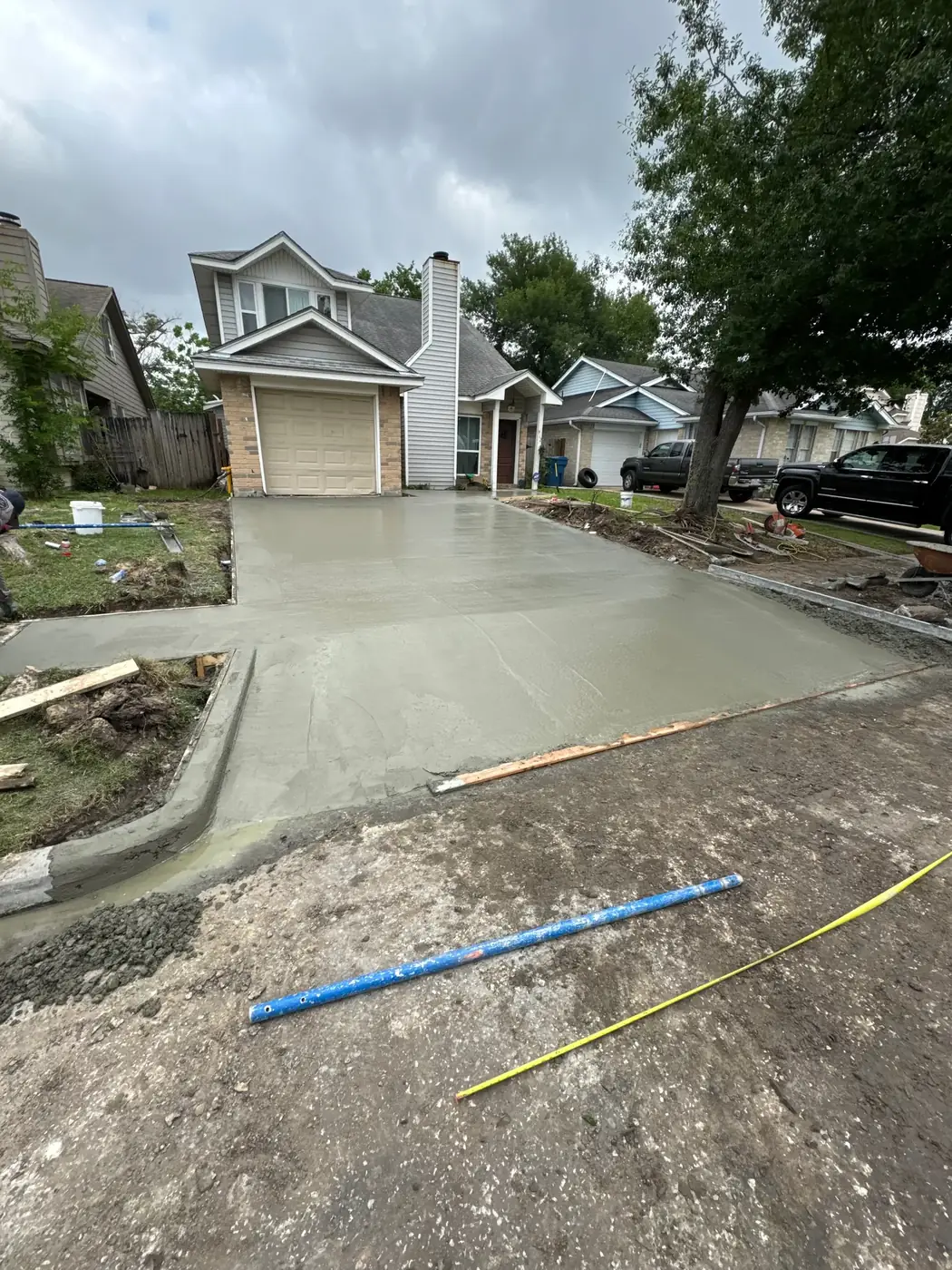 Freshly poured residential driveway slab in front of a home