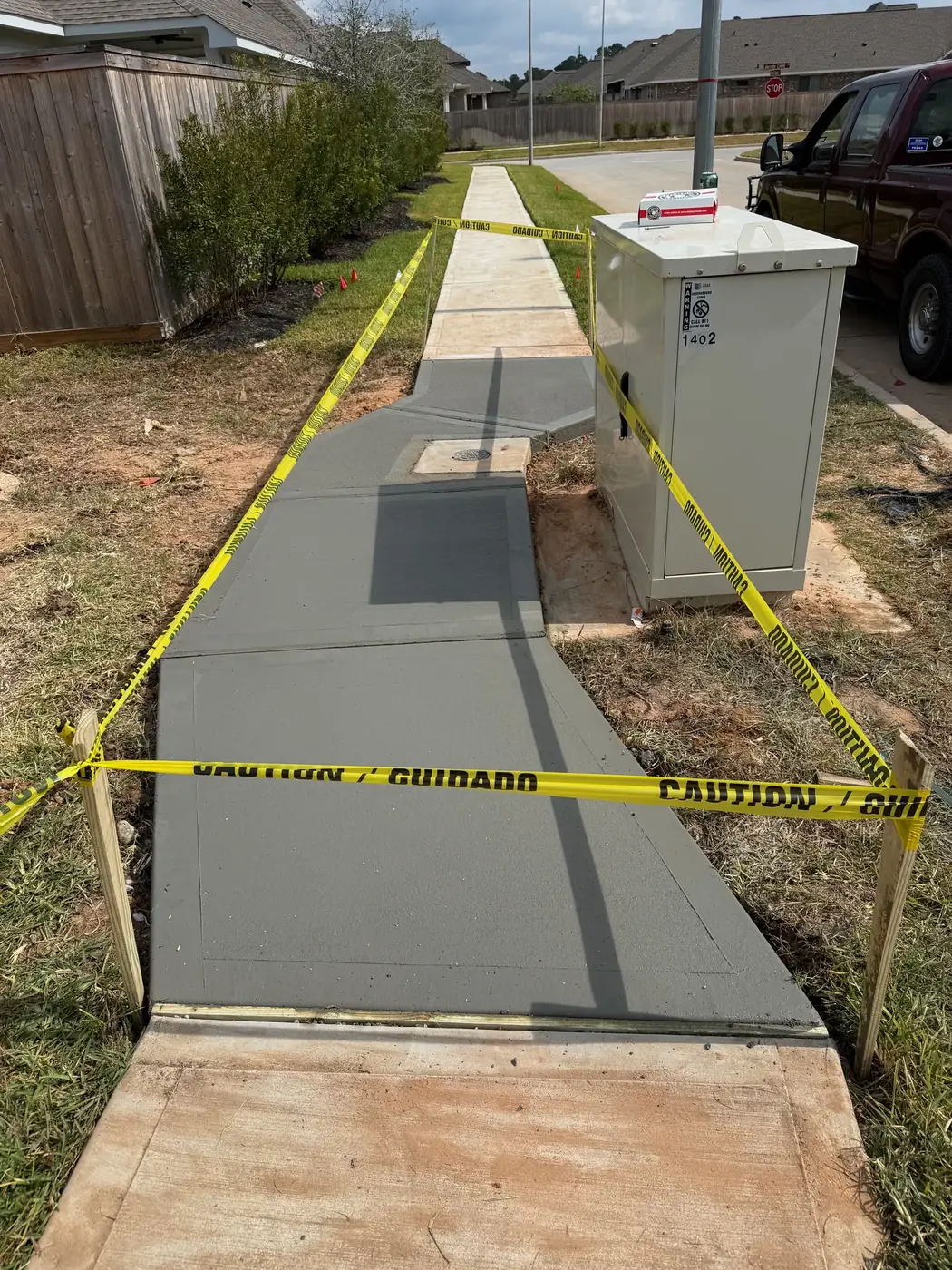 Fresh concrete sidewalk section poured around utility access