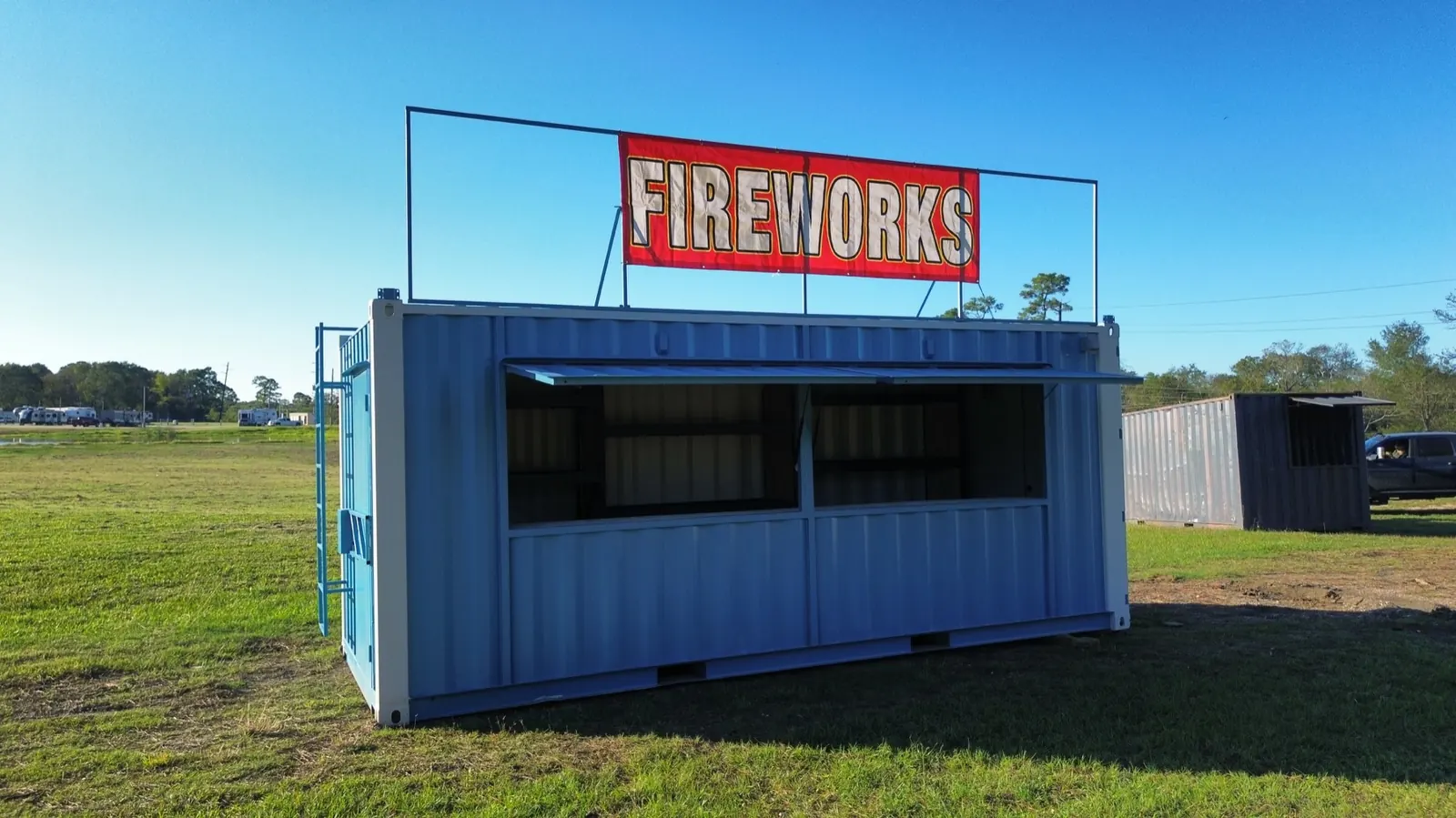 Blue shipping container fireworks stand with large fireworks sign