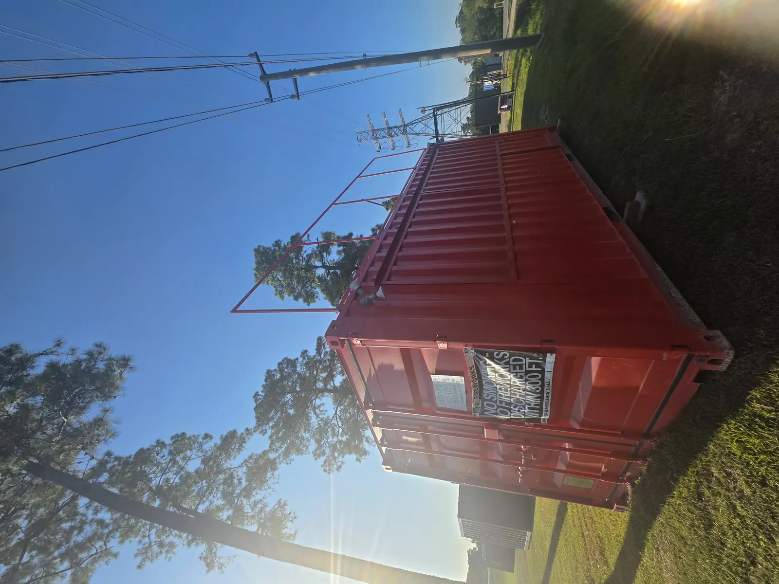 Side view of red fireworks container stand with mounted signage
