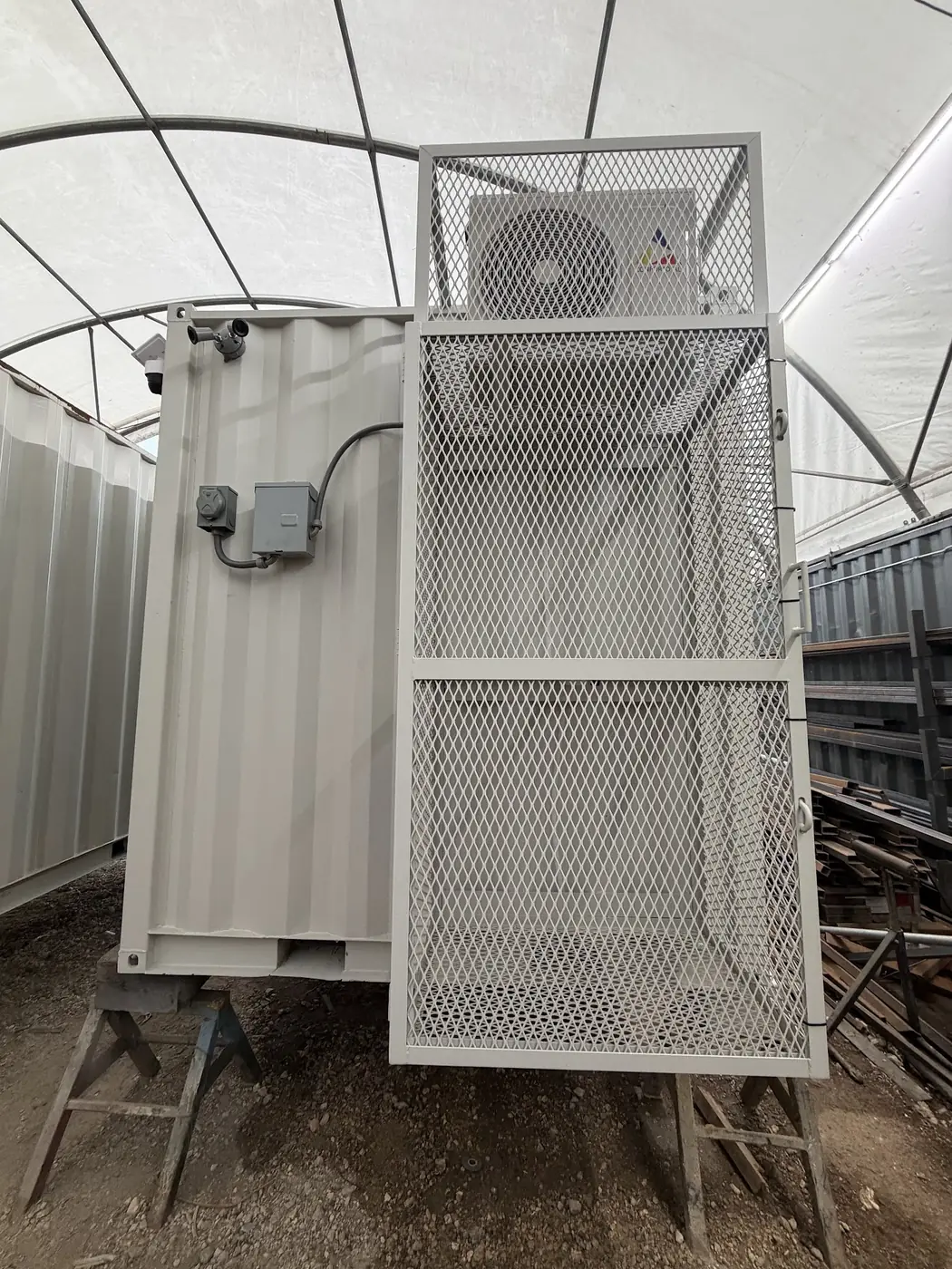 Security cage protecting HVAC and electrical equipment on a container