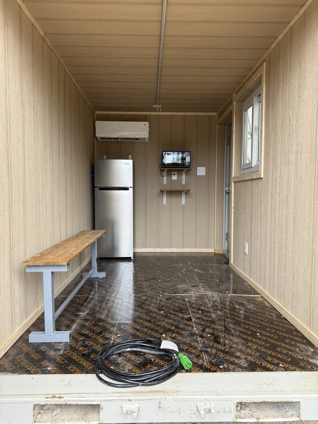 Container interior with refrigerator, bench seating, and finished walls