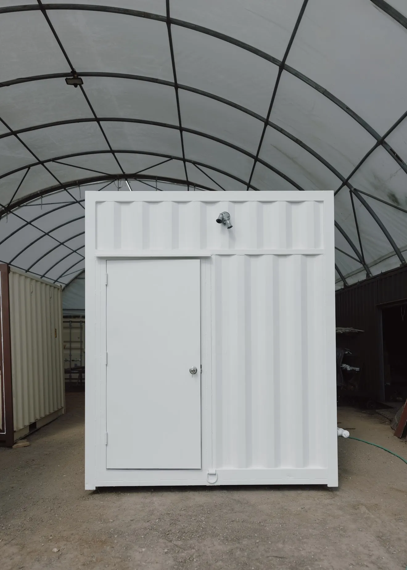 Compact white container building with personnel door